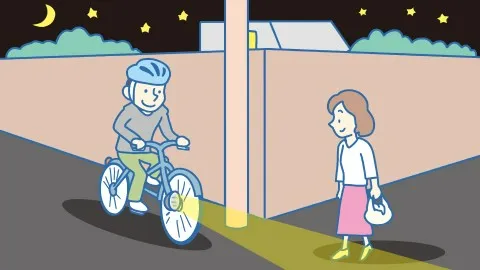 夜道でライトを点灯して走る自転車と、ライトの方向を確認する歩行者